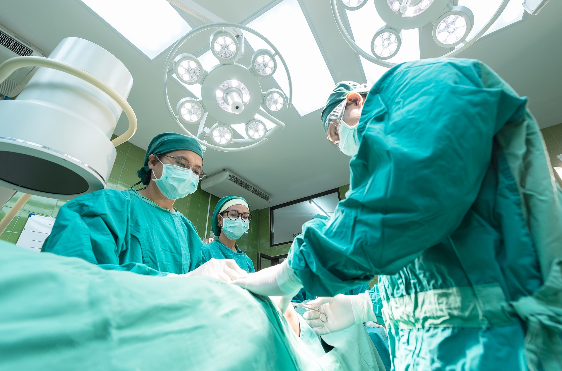Operationssaal mit drei Chirurgen